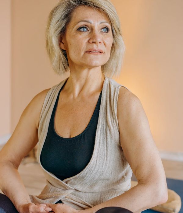 A person sitting peacefully with a serene expression, symbolizing inner well-being and calm.